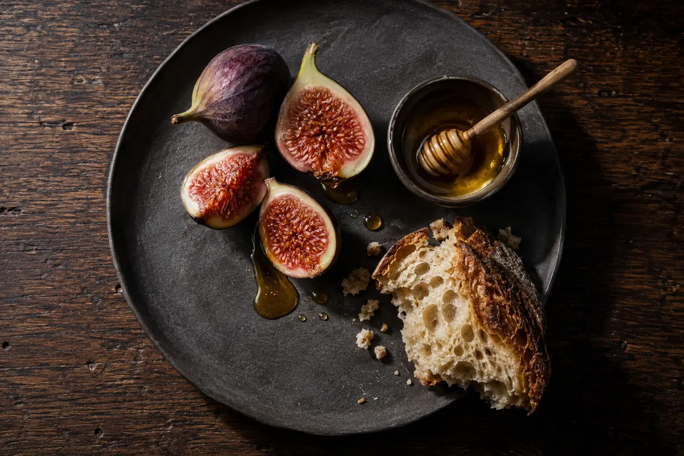 Fig Season, halved figs with honey and bread on slate