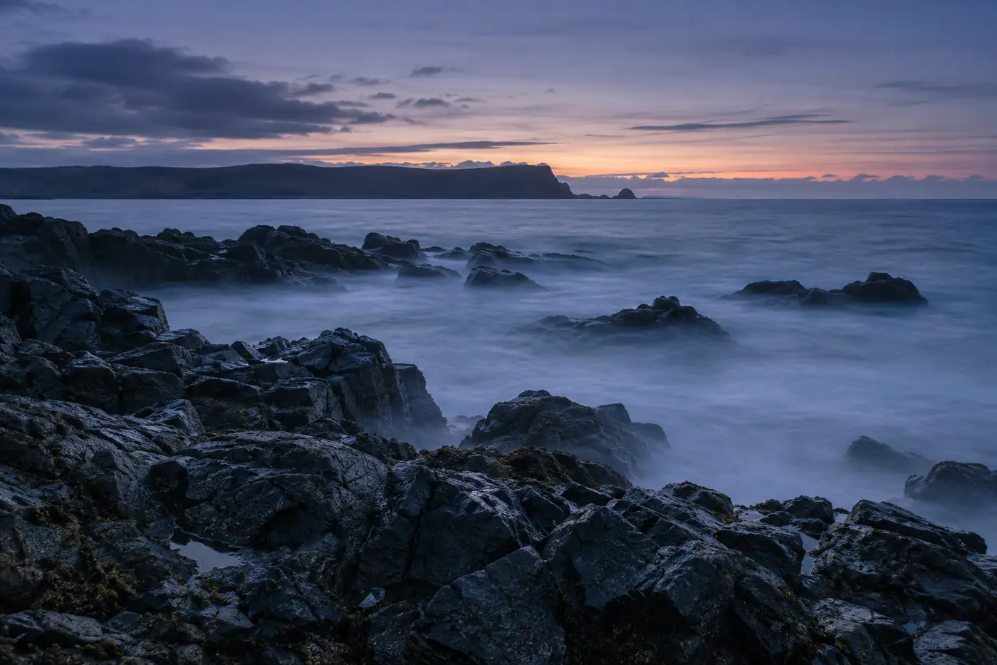 Basalt rocks and misty sea at blue hour